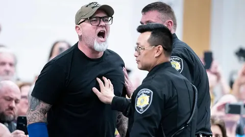 Asheville, North Carolina: A veteran being escorted out of a town hall for using his free speech.