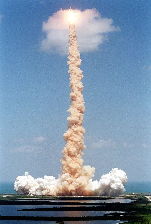 "Trailing a plume of smoke, Space Shuttle Endeavour pierces a small cloud, briefly lighting it from within, during launch on mission STS-100" from the John F. Kennedy Space Center in Florida, United States of America, on 19 April 2001. Photo credit: National Aeronautics and Space Administration