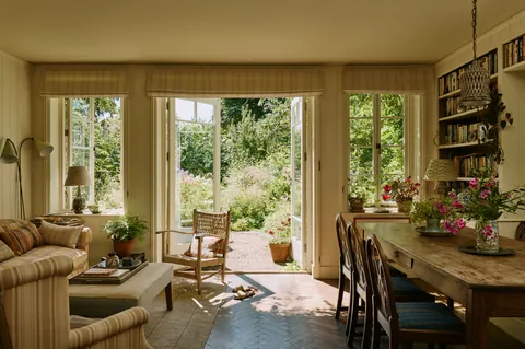 Light-filled living and dining space with wide French windows opening up to the garden in a renovated 1930s cottage, Richmond, southwest London, UK [3808x2534]