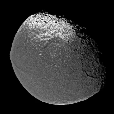 On New Year's Eve 2004, Cassini flew past Saturn's moon Iapetus, capturing images of its equatorial ridge, which contains some of tallest mountains in the solar system.