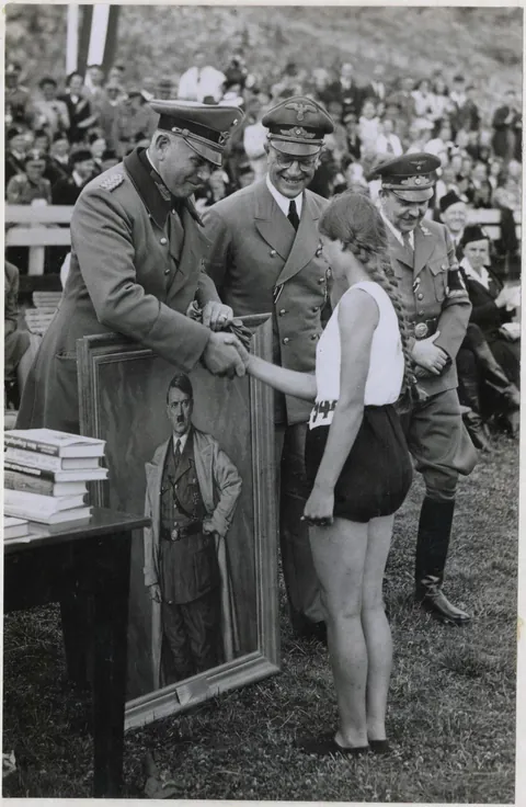 A Dutch athlete receives a portrait of Adolf Hitler as a sports prize