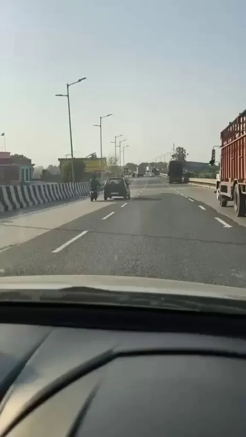 A mechanic performs Tochan an Indian technique for towing cars with two wheelers.