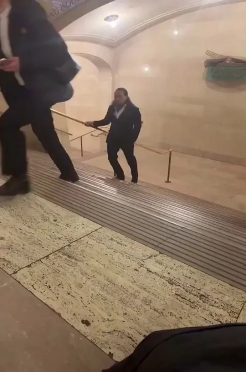 A man is walking backward so perfectly that it looks like the world is moving in reverse