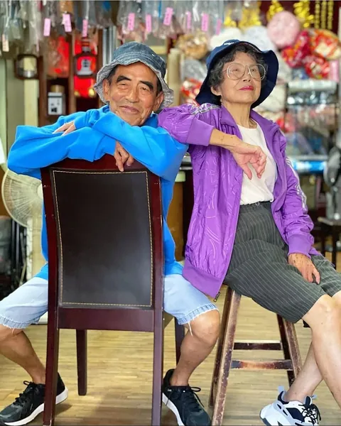 Taiwanese couple wear clothes that were left behind at their laundromat.