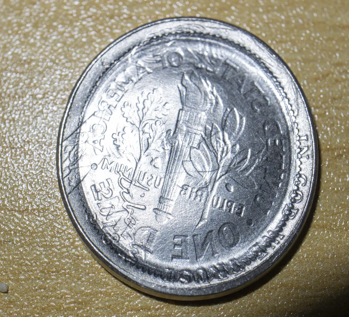 A dime imprinted into a nickel by a train wheel