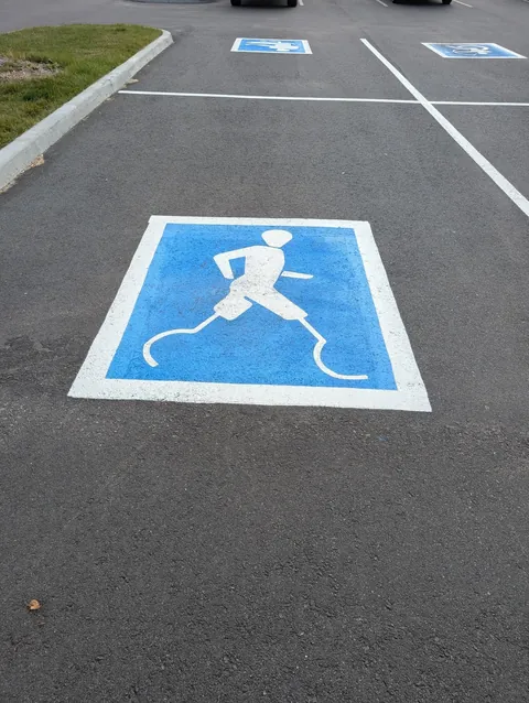Spotted creative handicap parking signs depicting different parasports outside a sporting goods store