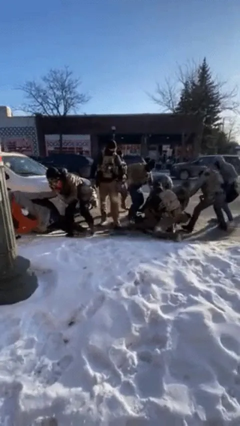 Slowed GIF of the murderer pulling his gun to shoot Alex Pretti in the back.