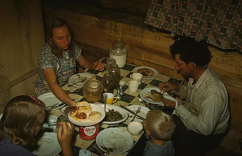 1940. Homesteaders Caudill Family sit down to dinner in their 'Dug-Out Home in Pie Town NM