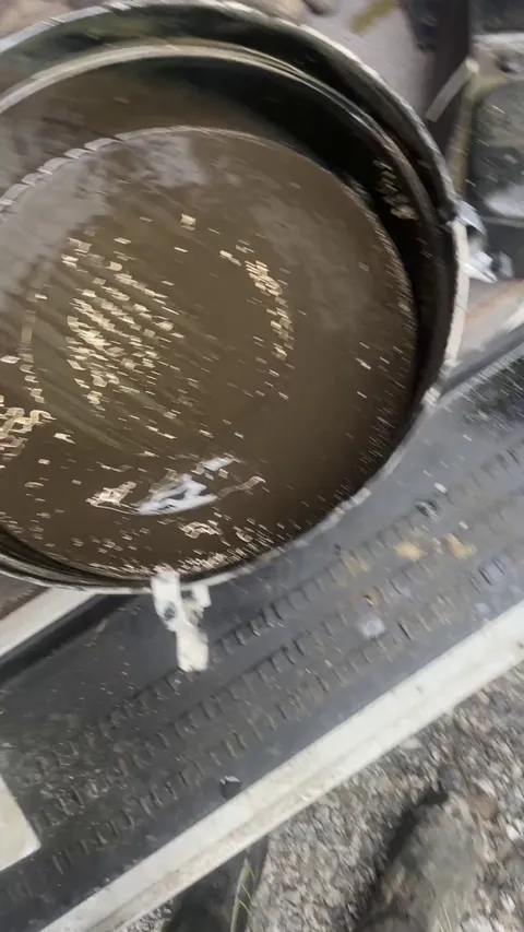 Cleaning out 500h collection of sediment in the  bottom of an oil bath air cleaner on a wheel loader Volvo L260H