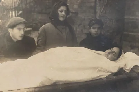 My great-grandfather (left) and his siblings, next to their deceased mother. Ukraine, 1920s.