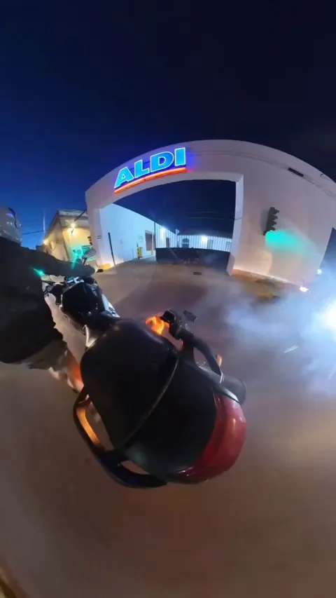 People help put out a motor scooter that is on fire.