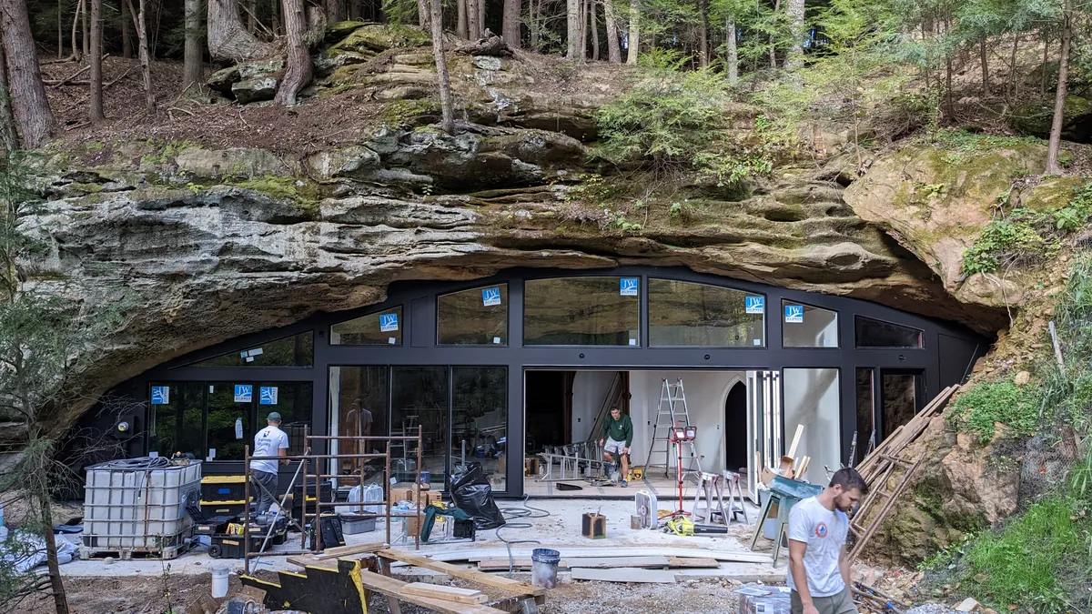 Is building under a huge rock like this safe? My first thought when I say this was earthquakes.