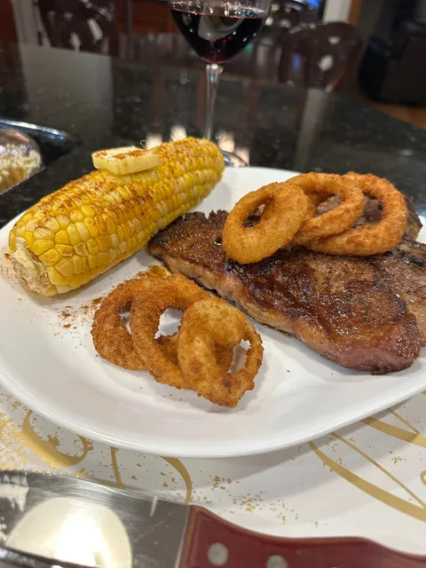 [homemade] 30oz porterhouse steak with onion rings and corn on the cobb.