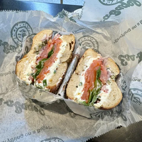 [I ate] A bagel topped with sliced salmon, tomato, lettuce, red onions, capers, and cream cheese.