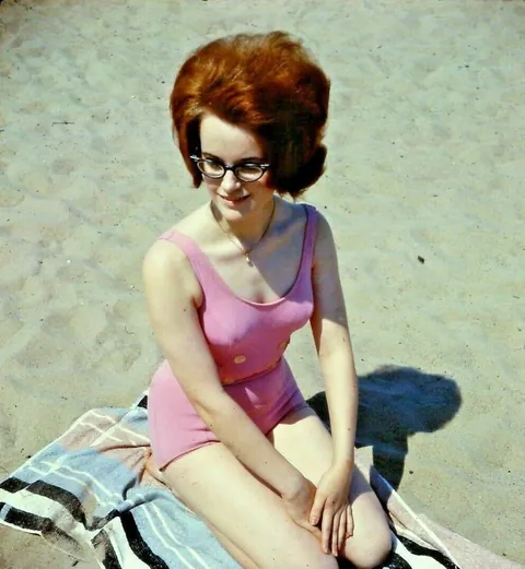 Lady poses at the beach with some friends, 1960s.