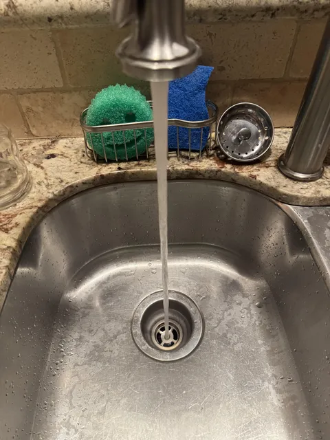 The water from our new kitchen faucet perfectly aligns with the hole in the drain