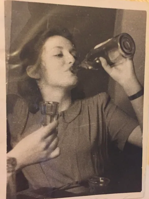 My babushka, in her twenties, downing vodka straight from the bottle. Soviet Union, late 1950s