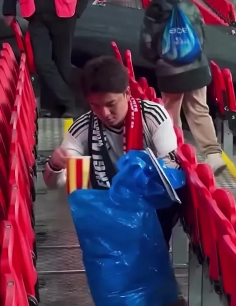 Japanese football fans cleaning up rubbish after their match against England at Wembley