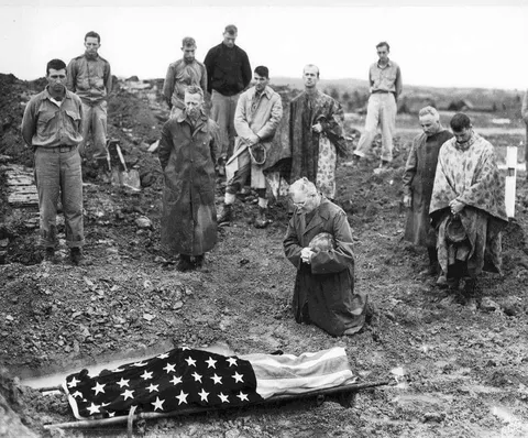 U.S. Marine Colonel Francis Fenton conducting the funeral of his son Private First Class Mike Fenton near Shuri, Okinawa, in May, 1945.