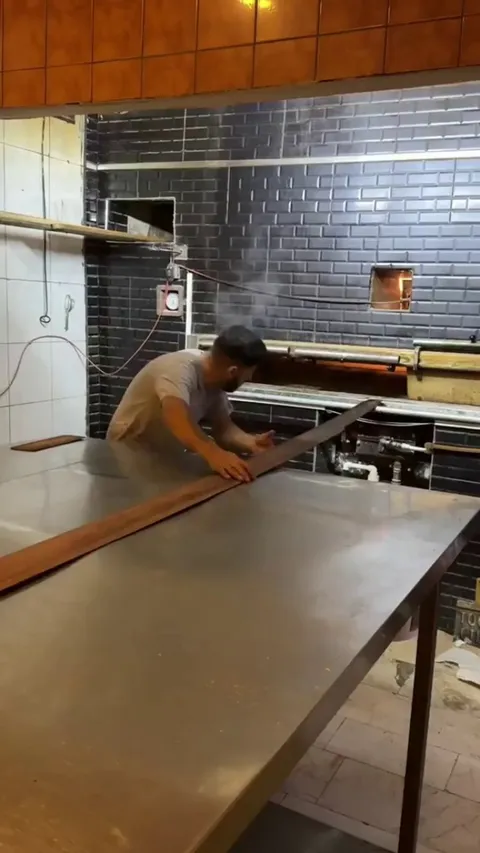 The lines of bread this man pulls out of the oven