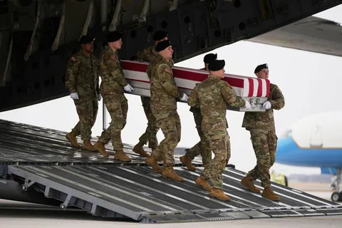 An Army carry team moves a flag-draped transfer case with the remains of Sgt. Declan Coady, 20.