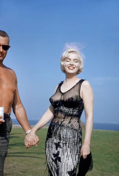Marilyn Monroe during her free time filming "Some like it hot" in 1959. That is her makeup artist. Color by kodachrome.