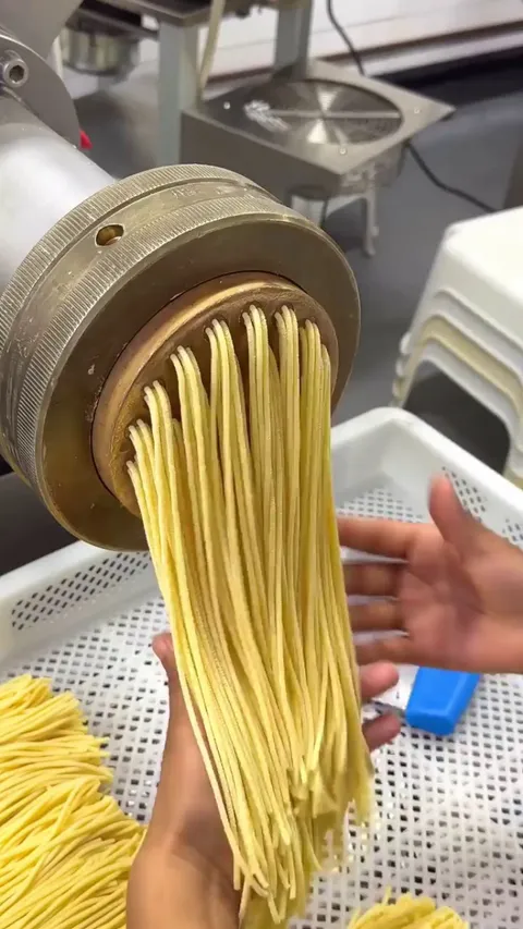 Spaghetti being extruded and cut