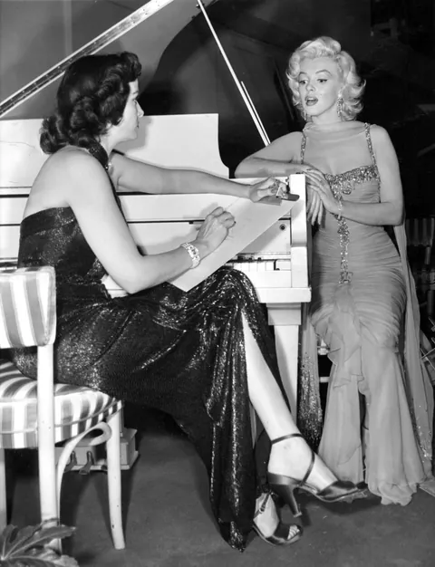 Actress Jane Russell shows off to Marilyn one of her talents, being a great pencil artis and drawing her during a break from the film of "Gentlemen prefer blondes", 1953