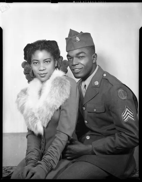 Young good looking couple pose for their photo circa 1940s. The man has a great smirk