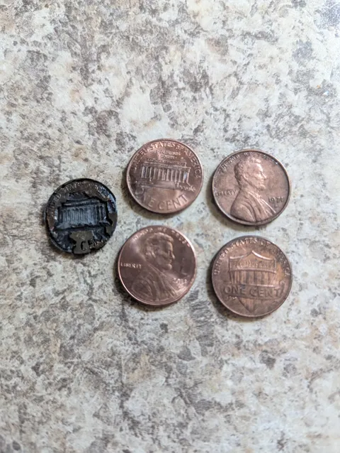 Pennies soaked in salt &amp; vinegar overnight, one is totally dissolving