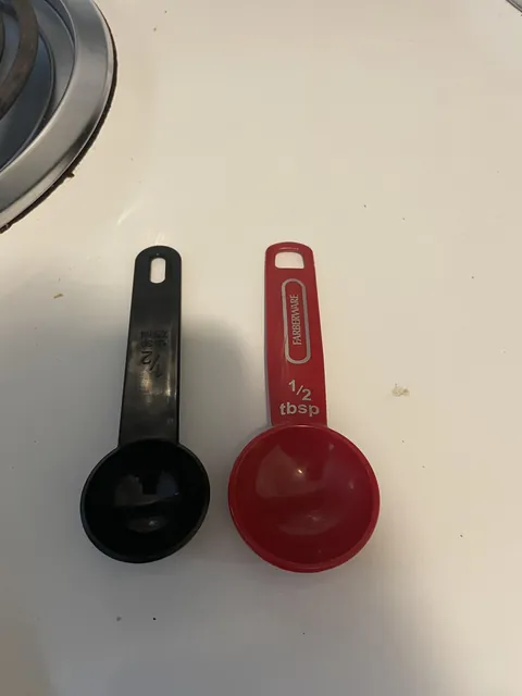 Slightly different sized spoons both labeled 1/2 tbsp