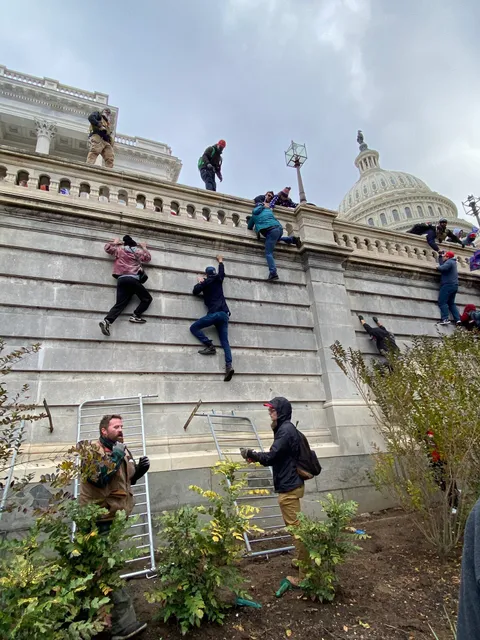 Trump Protestors climbing the walls outside the Capitol