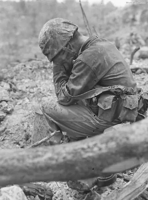 An overwhelmed US Marine is pictured while weeping among ruins during the Battle of Peleliu. September 26th, 1944. 
