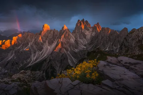 Sky opened up for just 5 minute to cast this light on the peaks and a rainbow. Dolomites, Italy (1600x1067)(OC)