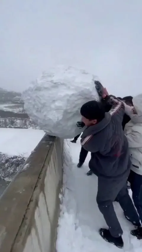 Pushing a gigantic snowball over the side of a bridge