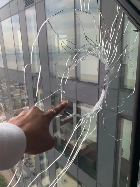 What can this giant hole on the 31st floor of my apartment building be? Woke up to a HUGE hole on the exterior window, there's no building in front of us and the terrace is on 12th floor. WTF is this???