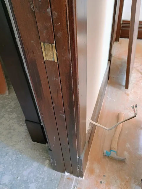 The electricians drilled through the pocket door that pulls out of the frame/wall, now the door doesn't open