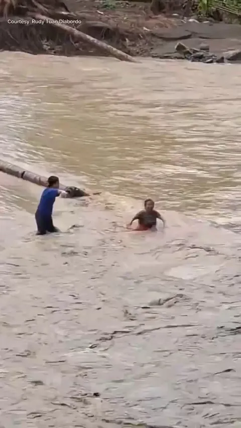 Teachers in a remote town in the Philippines, risk crossing a raging river after the typhoon washed away their only bridge.