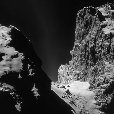 10 years ago, ESA's Rosetta spacecraft discovered this 1km high colossal cliff on the surface of Comet Churyumov–Gerasimenko. Due to the comet's extremely low gravity, a jump from this cliff might actually be survivable, and you'd land on a terrain surrounded by 20-meter-wide boulders