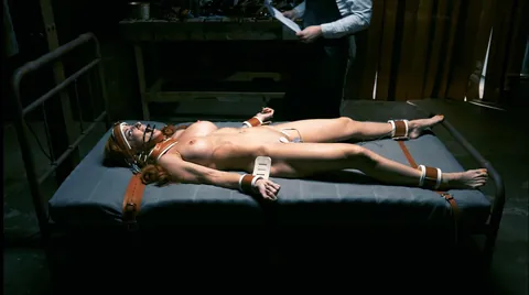 Strapped down tight to the bed with no escape.