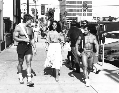 Arnold Schwarzenegger and Franco Columbu, walking with a girl in California, 1970s. 