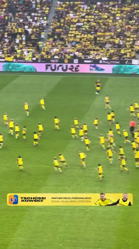 Piszczek dribbles against lots of children at the farewell match