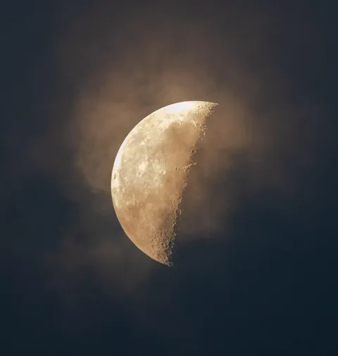 46% Waning Gibbous through thin clouds at dawn