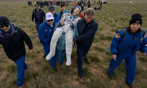 Don Pettit gives a thumbs up as he is carried to a medical tent shortly after landing in Kazakhstan