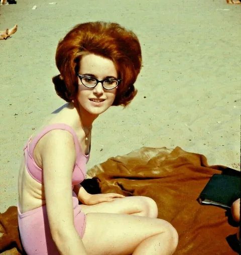 Lady poses at the beach with some friends, 1960s.