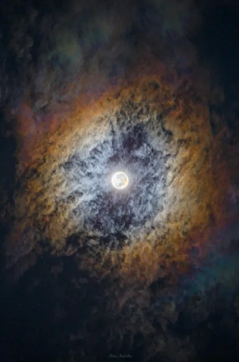 The Supermoon’s light caused iridescence in the cirrostratus clouds, painting them with a rainbow colors [OC]