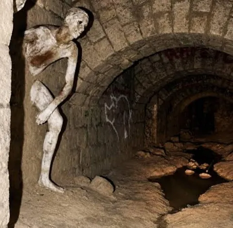 the statue inside the tunnel Le Passe-Muraille (man passing through wall)