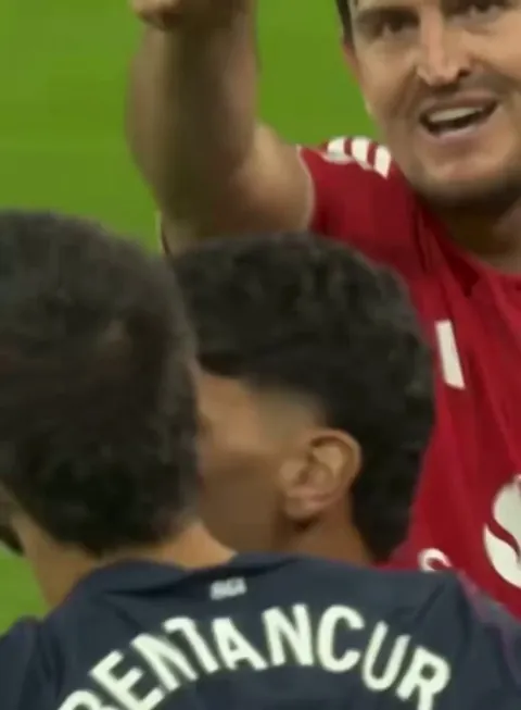 Harry Maguire laughs and waves off Rodrigo Bentancur following his red card.