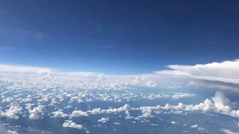 Plane flying past a storm