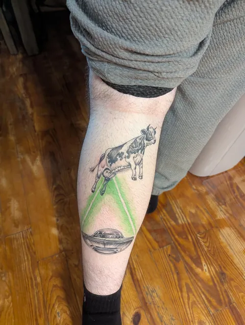Cow abducting a UFO done by Mitch H at Dark Arts Studio in Lebanon, MO